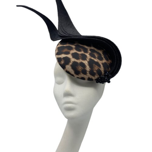Leopard print headpiece with black swirl detail and black beads to the base of the swirl.